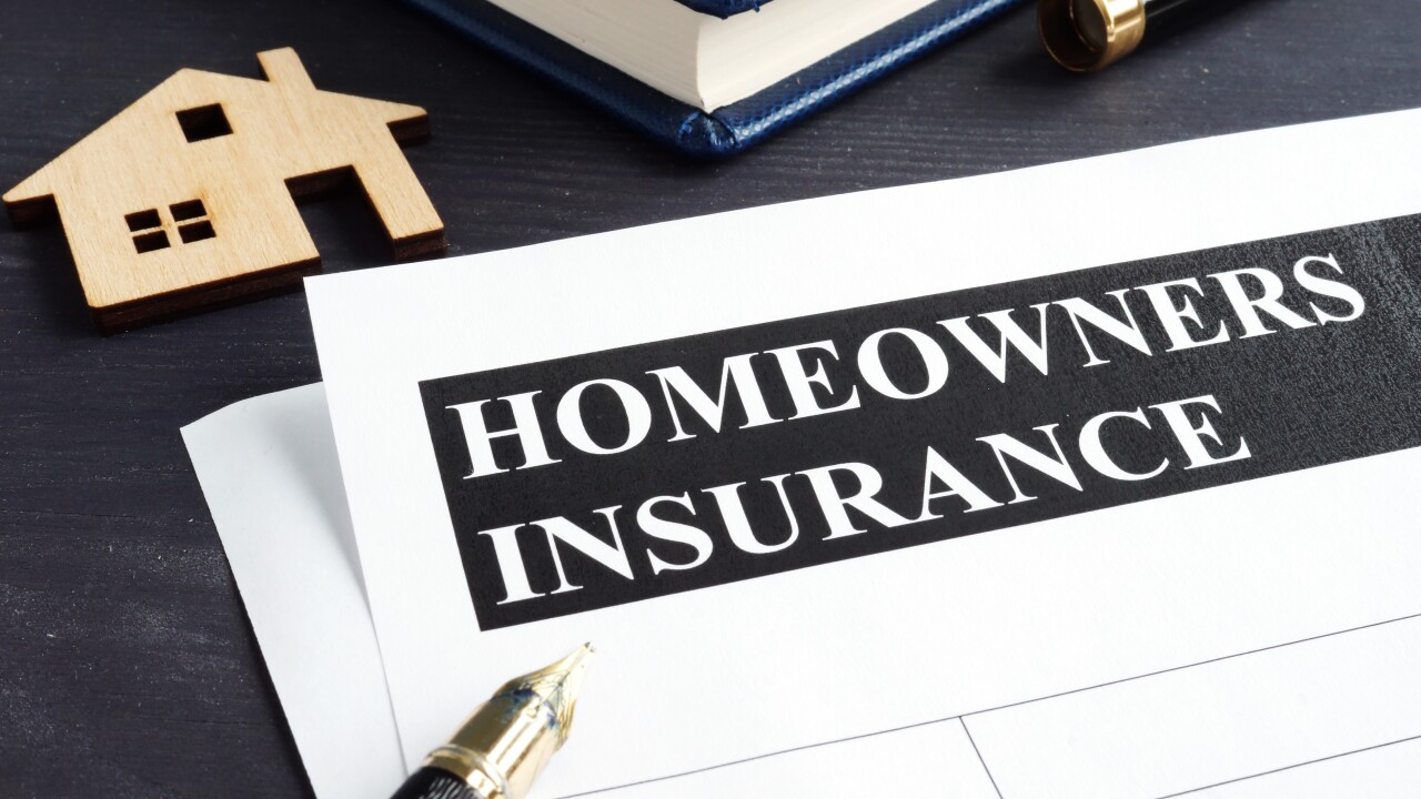 Homeowners insurance policy and model of home.
