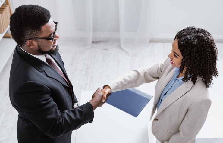 Black man shaking hands with a Black female