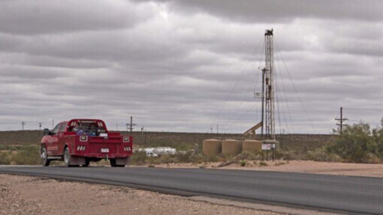 A truck passes a horizontal drilling rig in Lea County, New Mexico.
