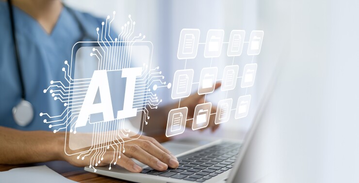 A health professional working at a laptop.