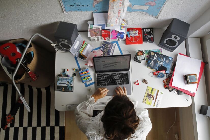 A woman works at an Apple Inc. laptop computer on a desk in a children's bedroom in this arranged photograph taken in Bern, Switzerland, on Saturday, Aug. 22, 2020. The biggest Wall Street firms are navigating how and when to bring employees safely back to office buildings in global financial hubs, after lockdowns to address the Covid-19 pandemic forced them to do their jobs remotely for months. Photographer: Stefan Wermuth/Bloomberg