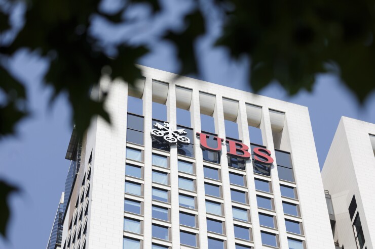 The UBS Group AG logo sits on the bank's skyscraper offices in Frankfurt, Germany, on Tuesday, July 17, 2018. Frankfurt's efforts to attract bankers escaping Brexit are in danger of losing momentum. Photographer: Alex Kraus/Bloomberg