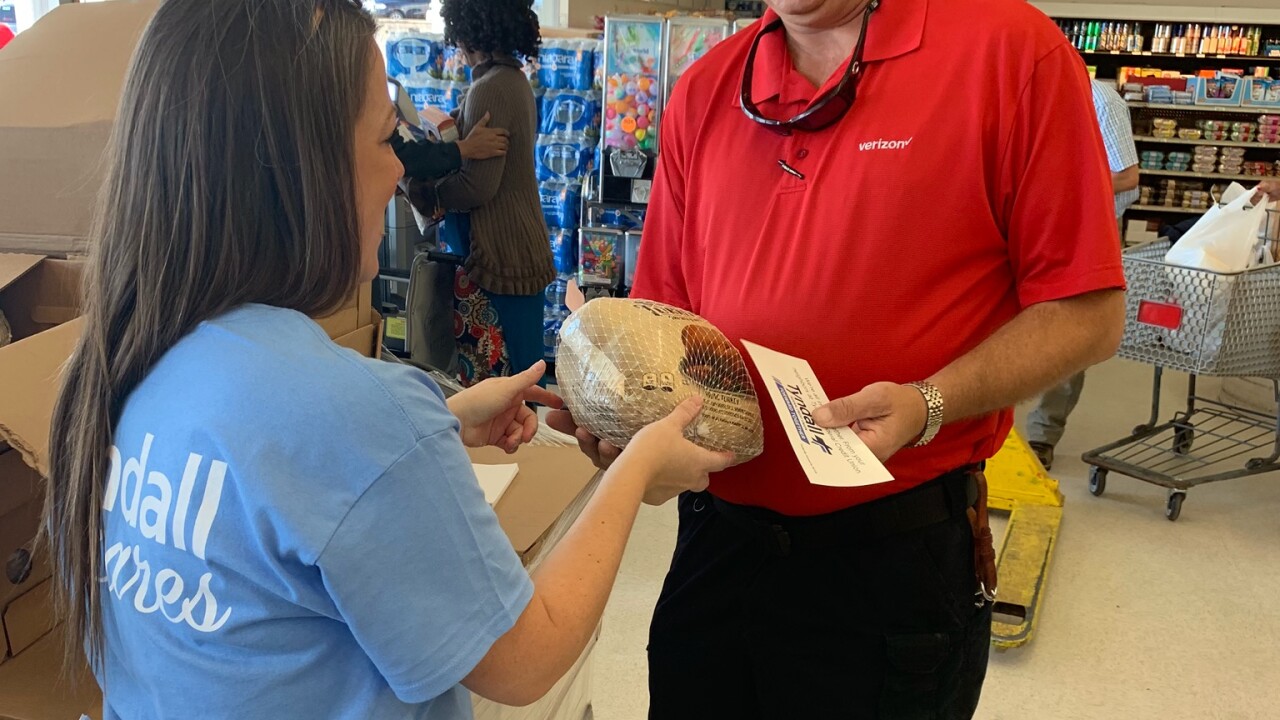 A Tyndall FCU employee hands out a free Thanksgiving turkey.