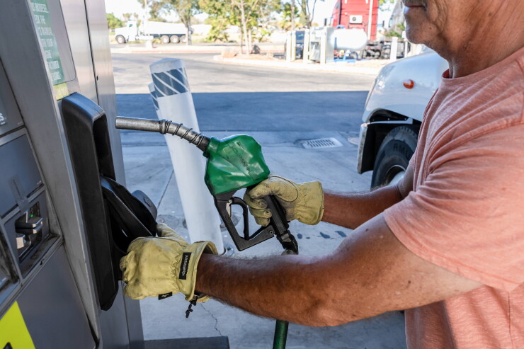 A driver returns a fuel nozzle after refueling a tractor trailer with diesel fuel at a Chevron truck stop in Tracy, California.