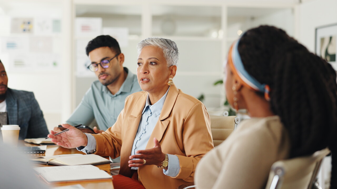 Group of employees talking at conference table