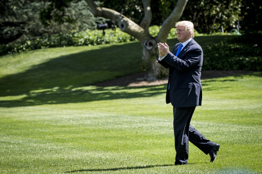 President Donald Trump applauds while walking to Marine One on the South Lawn of the White House.