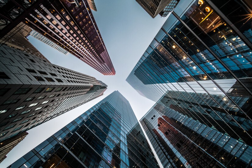 Looking up at high rise office buildings and the sky.