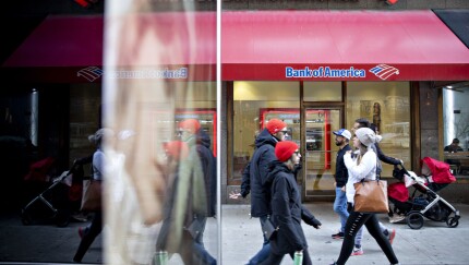 Pedestrians walk past a Bank of America branch.
