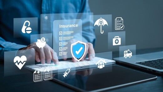 A person using a keyboard with a holographic image that reads insurance overlayed