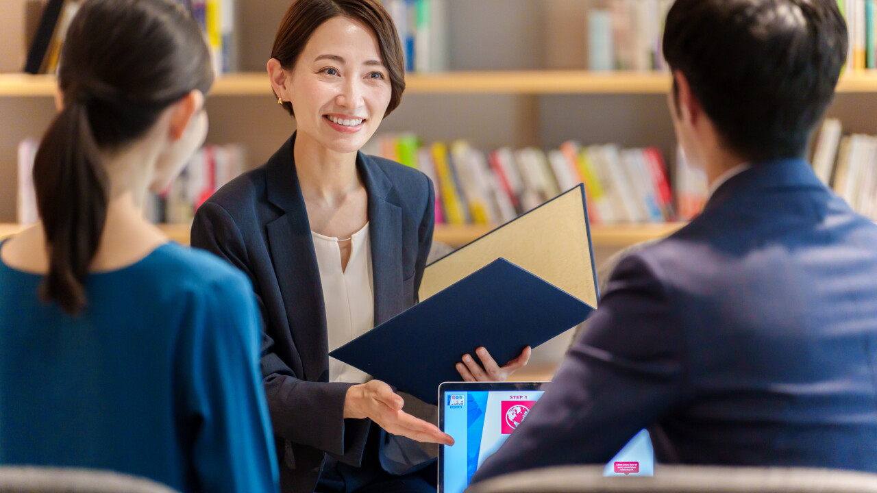 Asian female financial advisor with clients