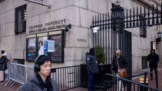 People walk near an entrance to the Columbia University campus