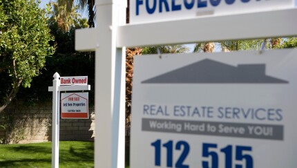 Closeup of real estate signs at foreclosed property