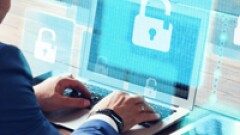 Personal working on a computer with a large image of a lock on the screen.