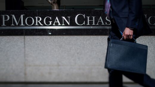 A pedestrian walks by a JPMorgan Chase sign.