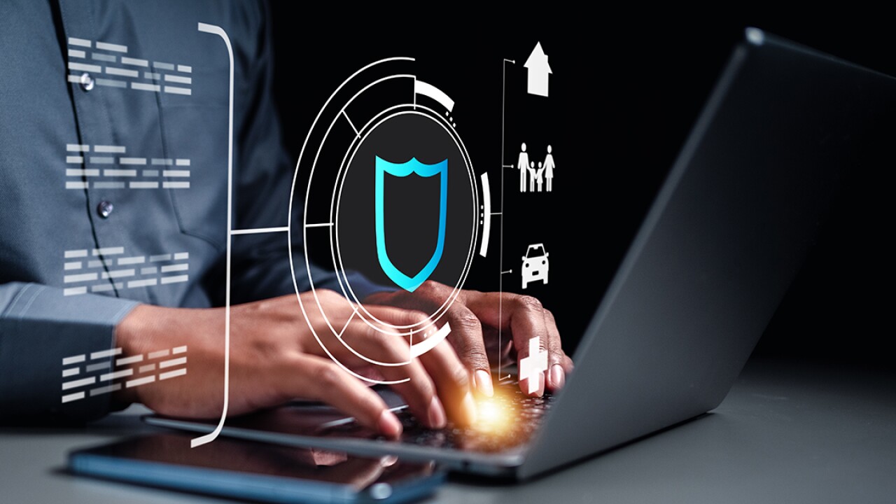 Person typing on a laptop with various figures representing insurance floating above the keyboard.