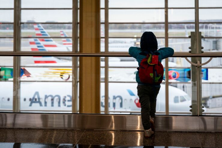 Young traveler views airplanes at Reagan National Airport in Arlington, Virginia