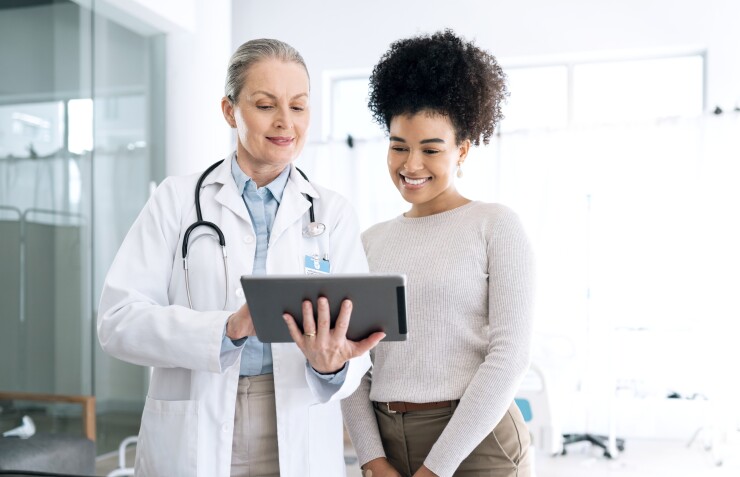 Female patient speaking with female doctor, smiling