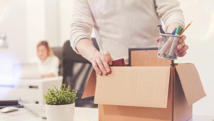 Sad dismissed worker taking his office supplies with him
