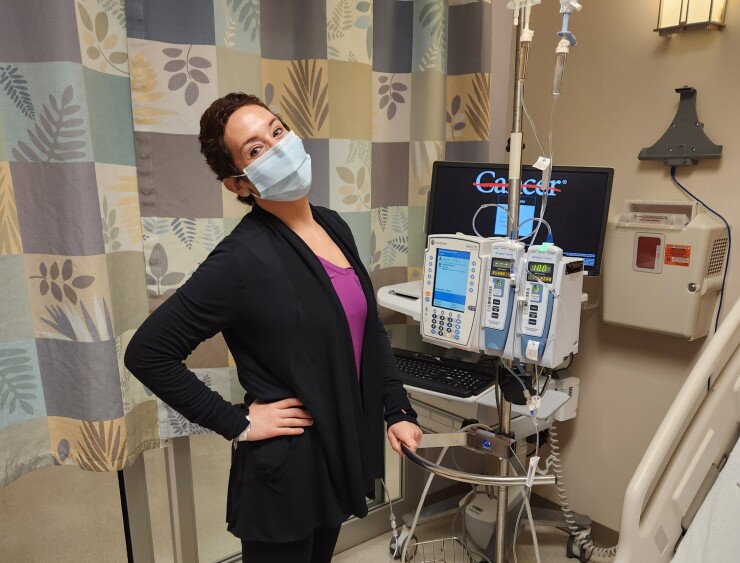 Woman receiving treatmen, wearing cap and mask in hospital