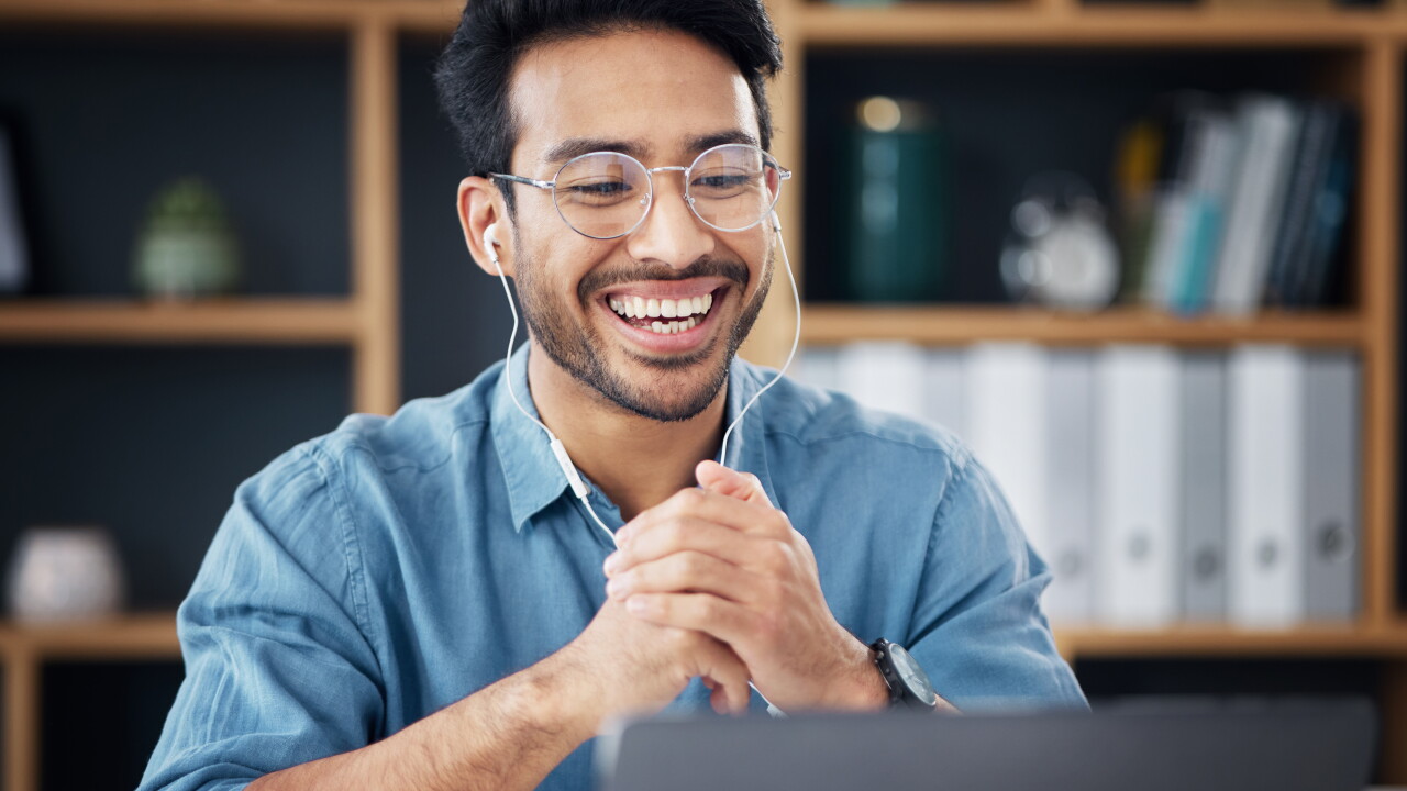 Man on video call, earbuds in, smiling