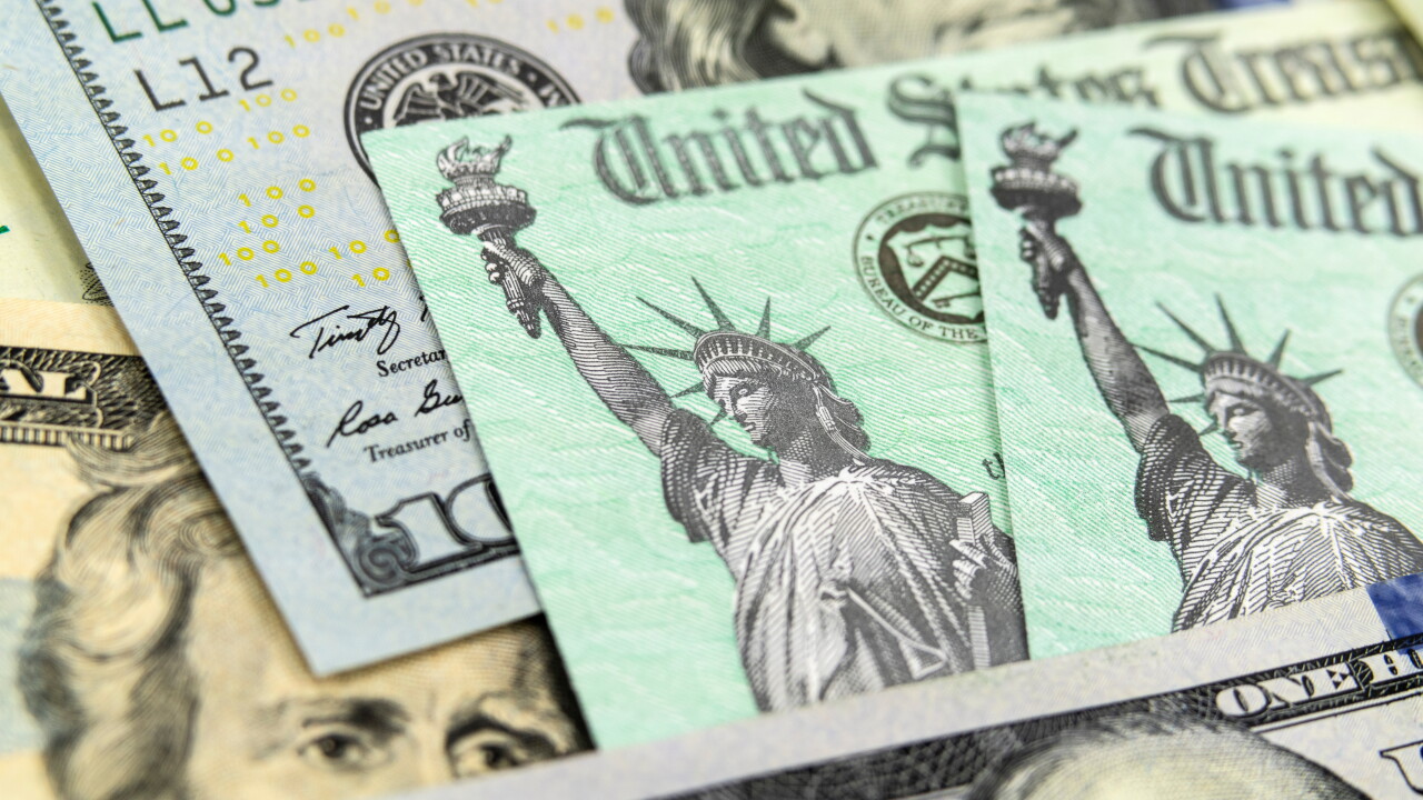 Macro view of the Statue of Liberty on a United States Treasury Checks with currency in background