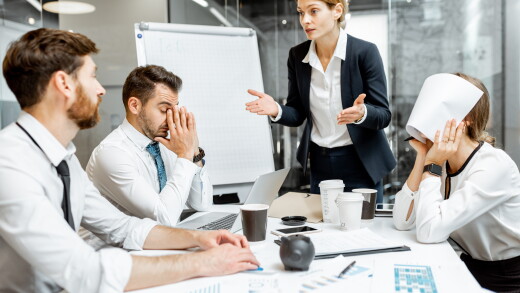 Female employees speaking to team, workers stressed, employee with paper over her face, upset
