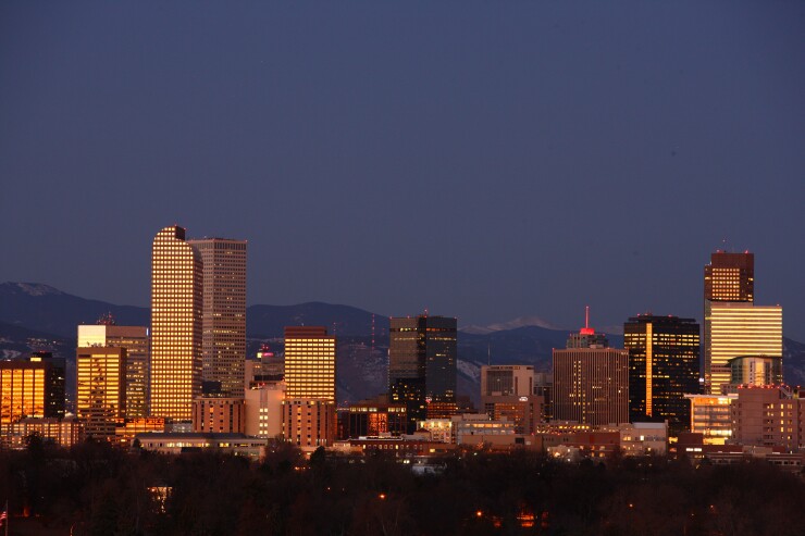 The Rocky Mountains form the backdrop to the city's skyline in Denver, Colorado, U.S.