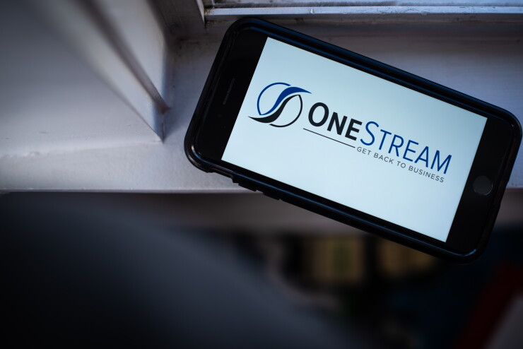 The OneStream logo is displayed on a mobile phone in an arranged photo