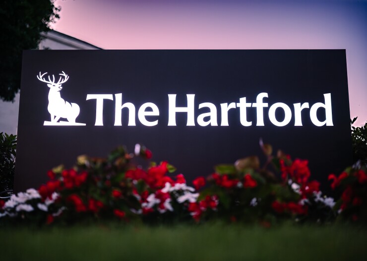 A sign reading the Hartford in with flower bushes in front.