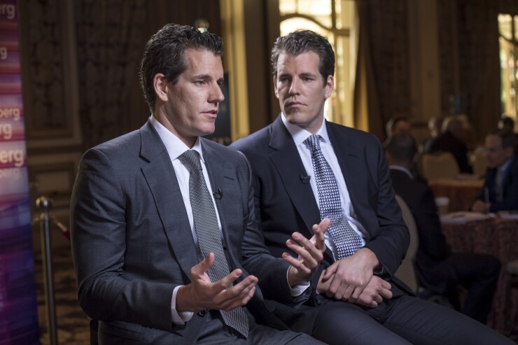 Cameron Winklevoss, chief executive officer and co-founder of Gemini Trust Company LLC, left, speaks as Tyler Winklevoss, chief financial officer and co-founder of Gemini Trust Company LLC, listens.