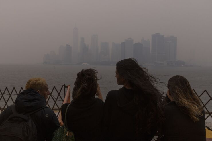 Staten Island Ferry passengers look at smoke-shrouded Lower Manhattan in June 2023