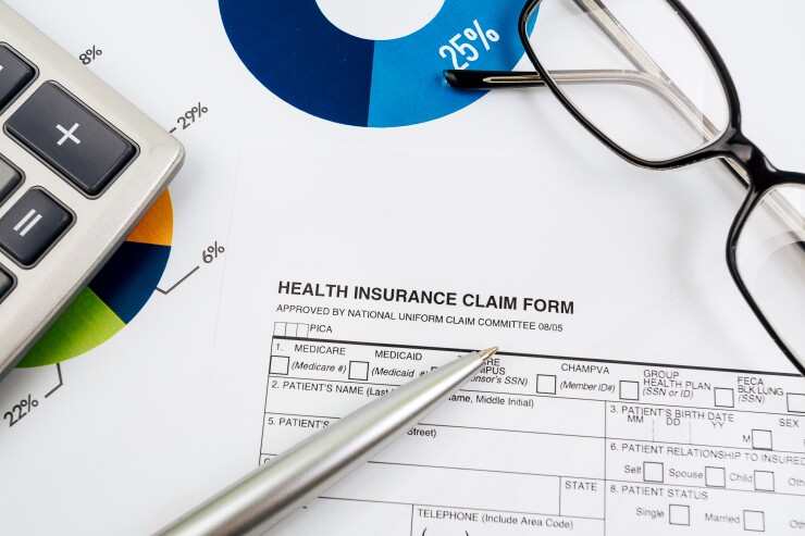 Health insurance claim form with eyeglasses and a calculator