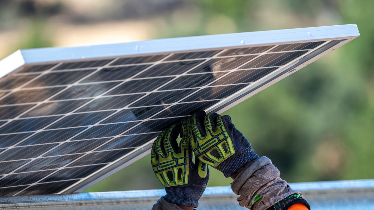 Contractors install solar panels.