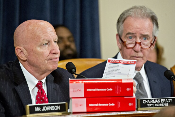 Representative Kevin Brady, a Republican from Texas and chairman of the House Ways and Means Committee, left, holds up a "Simple, Fair 'Postcard' Tax Filing" card next to ranking member Representative Richard Neal, right, during a markup hearing in Washington.