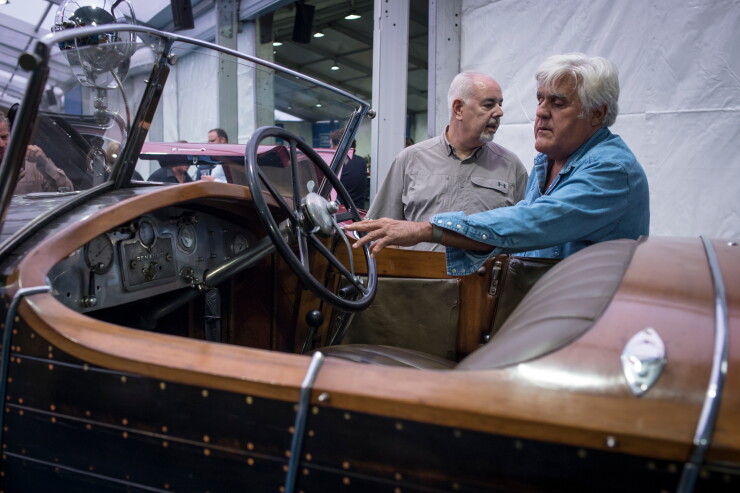 Jay Leno, right, views a 1925 Renault SA 40 CV Torpedo Skiff vehicle at the 2019 Pebble Beach Concours d'Elegance in California.