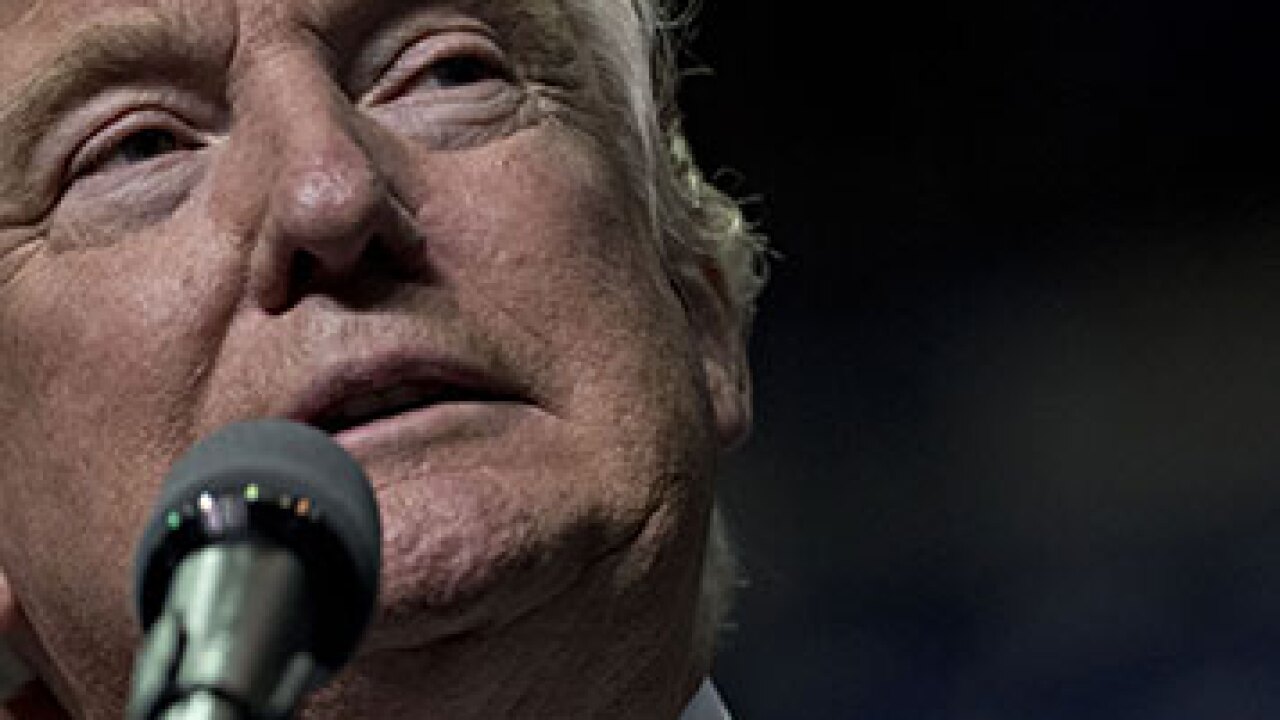 Donald Trump speaking into a microphone.