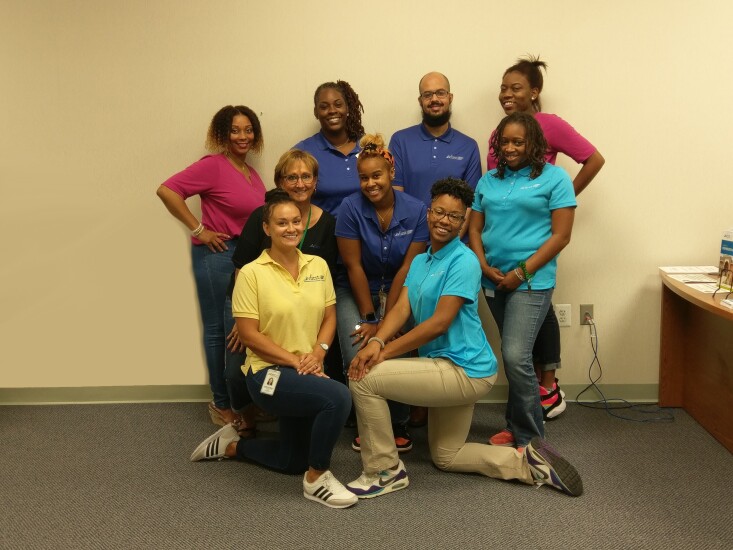 InFirst Federal Credit Union employees gather for a photo at the CU’s Marlow Heights branch location. Front row: Jacqueline Gullia, Training Development Manager; Ebony Makal, Marlow Heights Teller II. Second row: Patricia Irwin, Chief Operations Officer; Nia Coaxum, Marlow Heights Teller I; Shacerria Washington, Marlow Heights Teller I. Third row: Tahisha Hawkins, Marlow Heights Teller I; Michelle Lee, Marlow Heights Assistant Branch Manager; Darrius Thomas, Marlow Heights Teller II; and Lauren Cross, Marlow Heights Teller I.