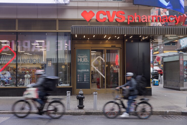 CVS store front with two bicyclists passing by.