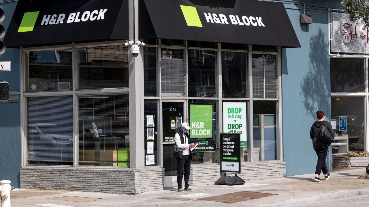 A person wearing a protective mask stands in front of an H&R Block office in San Francisco, California, U.S., on Monday, March 8, 2021. H&R Block Inc. is expected to release earnings figures on March 9. Photographer: David Paul Morris/Bloomberg