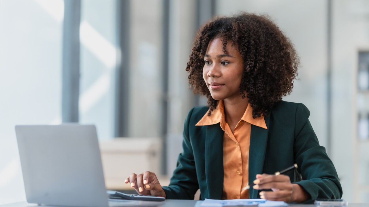 Female employee sitting at desk working on laptop