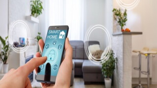 Person using their smart phone to operate electronics in their home.