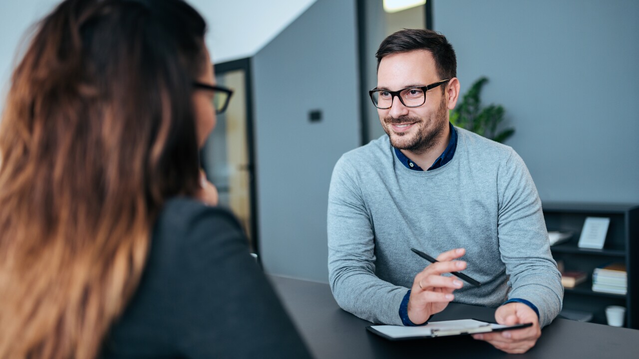 Woman and man sitting across desk having conversation
