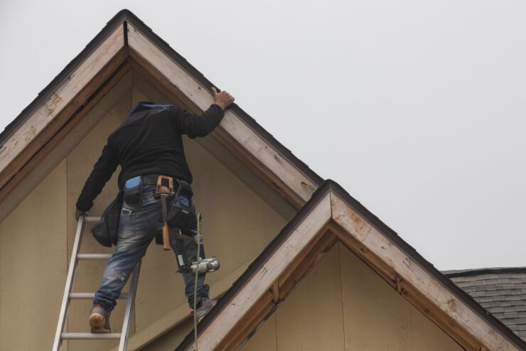 A construction worker applies trim to the roof of a new home in Foley, Alabama, US, on Wednesday, Dec. 21, 2022. New US home construction continued to decline in November and permits plunged as high borrowing costs paired with widespread inflation eroded housing affordability and demand. Photographer: Micah Green/Bloomberg