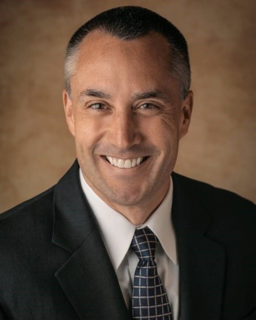 A man smiling for a portrait.