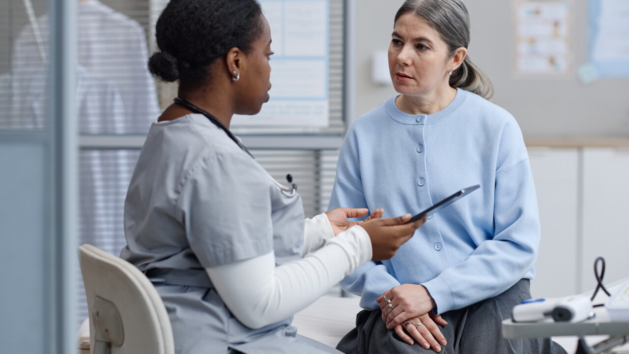 Woman speaking to nurse, doctor, sitting in office