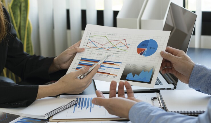Young businessman working with laptop and graphing documents in