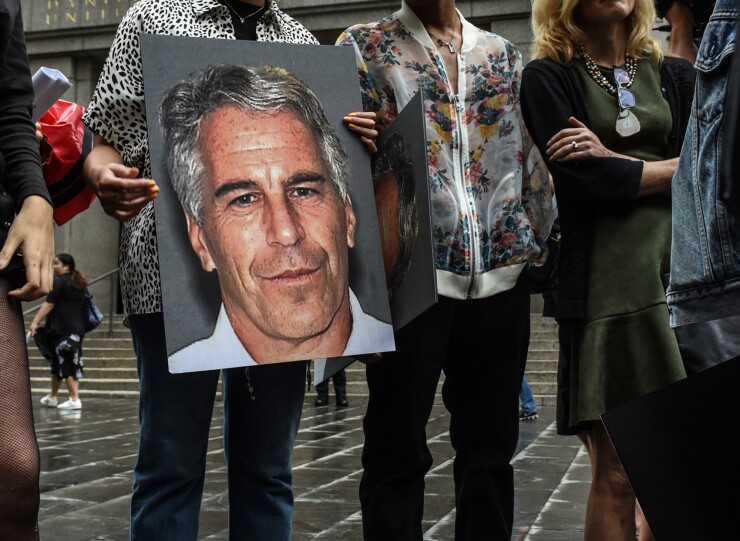 A protest group hold up signs of Jeffrey Epstein in front of the Federal courthouse in New York.