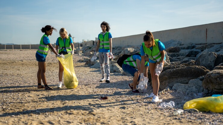 People picking up trash on beach