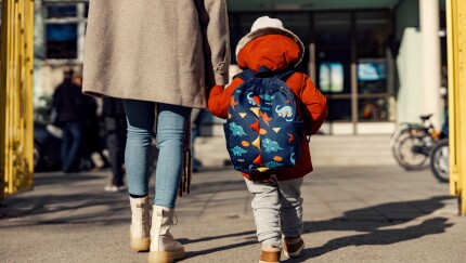Mother walking child into school, daycare