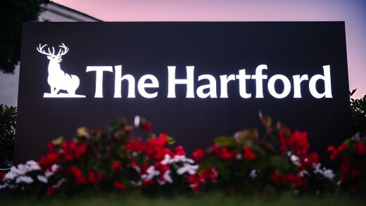 A sign reading the Hartford in with flower bushes in front.